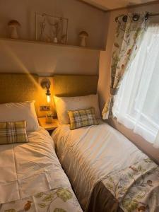 a bedroom with two beds next to a window at Luxury caravan in Morecambe