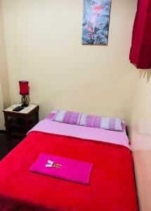 eine rote Decke auf einem Bett mit einer Serviette darauf in der Unterkunft KORICANCHA in Lima