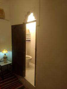 a bathroom with a toilet and a light on the door at Riad Dar Zaida in Marrakech