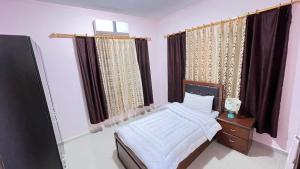 a bedroom with a bed and a window with curtains at Sara apartment in Wadi Musa