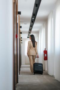 a woman walking down a hallway with a suitcase at Hotel Kod Barića in Grude