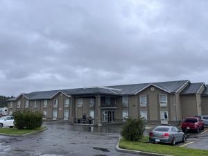 a building with cars parked in a parking lot at Super 8 by Wyndham Cranbrook in Cranbrook