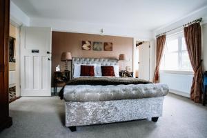 ein Schlafzimmer mit einem großen Bett und einem Sofa in der Unterkunft Lisnacurran in Hillsborough