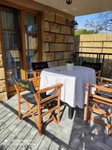 a table and chairs on a porch with a white table cloth at Kuca za odmor Milica in Vrnjačka Banja