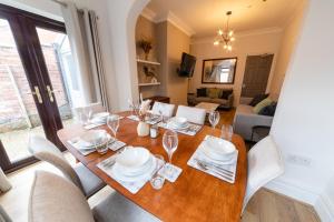 - une salle à manger avec une table et des chaises en bois dans l'établissement NEWLY REFURBISHED House - FREE Wi-Fi!, à Wyken