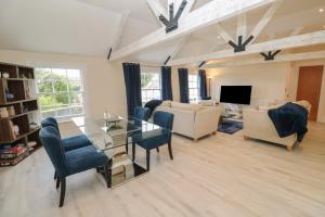 a living room with a glass table and chairs at The Penthouse in Helston