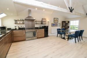 a large kitchen with a table and a dining room at The Penthouse in Helston