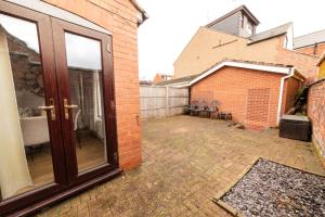a patio with a sliding glass door in a brick building at NEWLY REFURBISHED House - FREE Wi-Fi! in Wyken