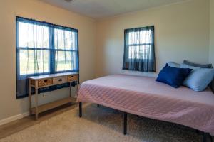een slaapkamer met een bed en 2 ramen bij Waterfront Rock Point Vacation Rental with Sunroom! 