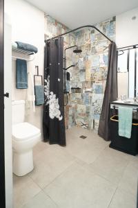 y baño con aseo y ducha con cortina de ducha. en Aldabea II apartamento sostenible, en Legazpia