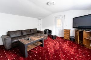 a living room with a couch and a flat screen tv at Hotel Haus Biggen in Attendorn