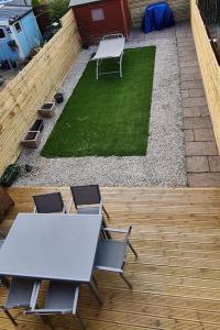 a white table and chairs on a wooden deck at Runway Airbnb in Manchester