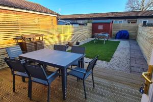 a patio with a table and chairs on a deck at Runway Airbnb in Manchester