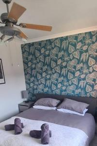 a bedroom with two beds and a wall with a floral wallpaper at Runway Airbnb in Manchester