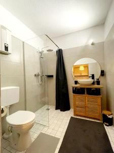 y baño con aseo, lavabo y ducha. en Savón - City Apartment, en Bad Oeynhausen