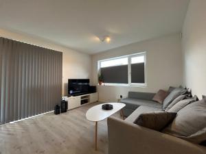 a living room with a couch and a table at Sørlandsidyll med svømmebasseng! in Kristiansand