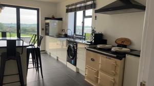 a kitchen with a washer and dryer and a table at Immaculate 3-Bed Barn in Uttoxeter in Uttoxeter