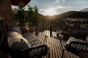a balcony with two chairs and a table and the sun at Hedarom in Sinaia