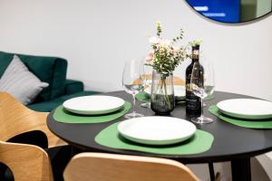 a table with plates and glasses and a bottle of wine at Hedarom in Sinaia