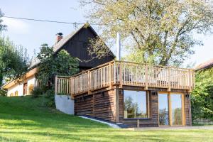 a house with a deck on the side of it at Das Ferienhaus mit Sauna! Neu renoviertes "Liebler Heimathaus" mit Sauna aus Zirben-Altholz, einer "Styrian Whisky Relaxing Lounge" sowie großer Panoramaterrasse! 