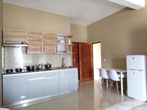a kitchen with white cabinets and a white refrigerator at Milestone City Business Apartment - Secure Area - Fast WiFi Long Stay in Antananarivo