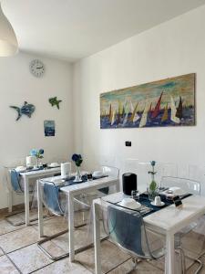 una stanza con tavoli e sedie e un dipinto sul muro di B&B Il Poeta sul Mare ad Ancona