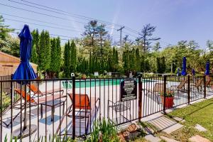 a fence with chairs and umbrellas next to a pool at Shorelands 44-2 in Kennebunk