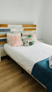 un letto con lenzuola e cuscini bianchi di Ático con Piscina y Vistas al Mar Parque Litoral a Málaga
