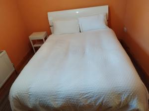 a bed in a small room with a white bedspread at Grange cottages in Edenderry