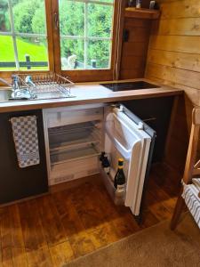 La cuisine est équipée d'un évier et d'un réfrigérateur ouvert. dans l'établissement Trekkershut, à Wallenborn