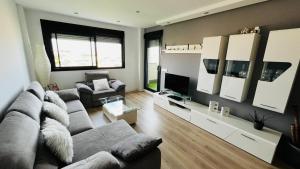 - un salon avec un canapé et une télévision dans l'établissement Ático con Piscina y Vistas al Mar Parque Litoral, à Malaga