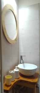 y baño con lavabo y espejo. en Entre Las Sierras Cabañas en Villa Giardino