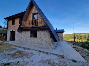 a house with a balcony on top of it at Vila Suvo vrelo in Jahorina
