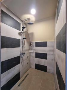 a bathroom with a shower with black and white stripes at Vila Suvo vrelo in Jahorina