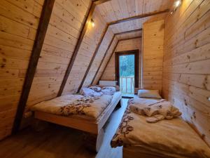 a bedroom with two beds in a log cabin at Vila Suvo vrelo in Jahorina