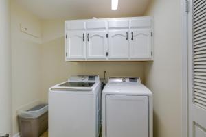una lavandería con 2 máquinas y un armario blanco en Spacious Southaven Home on 8 Acres with Private Pool, en Southaven