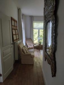 ein Wohnzimmer mit einem Spiegel und einem Sofa in der Unterkunft Kasteel Sint-Flora in Veurne