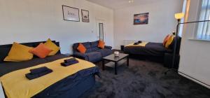 Sapphire Apartments في كارديف: غرفة معيشة بها سريرين وأريكة