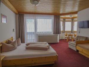 a bedroom with a large bed and a living room at Garni Apart Wallamotta Silvretta Card Premium Betrieb in Galtür