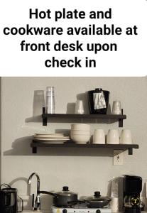 a kitchen counter with a shelf with dishes on it at Studio 6 Sacramento, CA Natomas in Sacramento