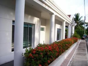 a white building with red flowers on the side of it at Casa Campestre El Peñon 5 Habitaciones in Girardot