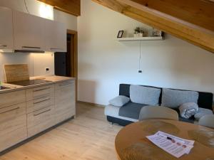 a kitchen and a living room with a table and a couch at Obereggen - Anna in Eggen