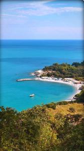 a beach with a boat in the middle of the water at Conero Casa - Marcelli di Numana in Piazzale Eolie 7 in Marcelli