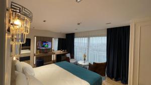 a bedroom with a bed and a desk and a television at Mona Bosphorus Hotel in Istanbul