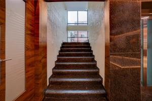 a staircase in a house with wooden walls and wooden floors at Townhouse OAK Ess Jay in Bangalore