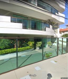 an external view of a building with glass windows at Férias em Família Apartamento Temporada in Cabo Frio