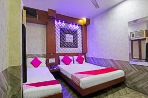 Łóżko lub łóżka w pokoju w obiekcie OYO Flagship Hotel Pink Palace