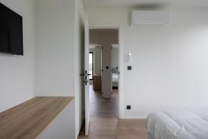 a bedroom with a bed and a flat screen tv at NIEUW - De Grenspaal WEST 6P 5 min Maastricht - Sauna - Laadpaal in Riemst