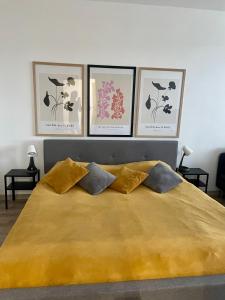ein Schlafzimmer mit einem großen Bett mit vier Bildern an der Wand in der Unterkunft City Ela Center in Košice