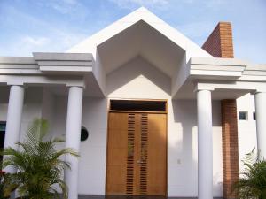 a white house with white columns and a brown door at Casa Condominio El Peñón Girardot in Girardot
